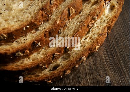 Brotscheiben auf einem dunklen Holztisch. Bäckerladen. Stockfoto