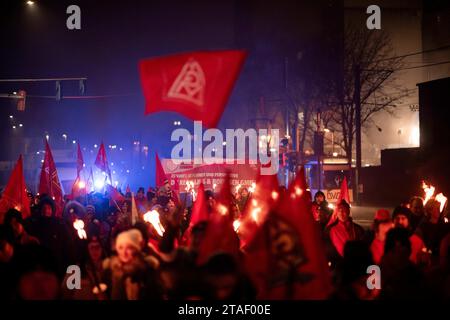 Duisburg, Deutschland. November 2023 30. Die Teilnehmer der Demonstration gehen während eines Protestes im Zuge des aktuellen Lohnstreits zur Aussichtsplattform. Gewerkschafter der Duisburger Stahlwerke und Delegationen der umliegenden Zweige kündigen symbolisch das Ende der Friedensverpflichtung an. Die Gewerkschafter machen einen fackelmarsch von der Hüttenschenke der Hüttenwerke Krupp Mannesmann zur Aussichtsplattform Tiger & Turtle in Duisburg. Quelle: Fabian Strauch/dpa/Alamy Live News Stockfoto