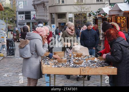 Brünn, Tschechische Republik 26. November 2023 : Frauen suchen an Marktständen auf dem Weihnachtsmarkt auf dem Kohl-Markt durch Metallkeksschneider Stockfoto