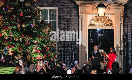 London, Großbritannien. November 2023 30. Premierminister Rishi Sunak und seine Frau Akshata Murty schalten zuerst die Weihnachtsbaumbeleuchtung ein, beobachtet von den eingeladenen Gästen, dann besucht er einen festlichen Markt, auf dem britische Unternehmen präsentiert werden, mit Verkaufsständen außerhalb der Downing Street 10 in Westminster. Der Premierminister und seine Frau unterhalten sich mit mehreren Ständen, obwohl der Rundgang kürzer ist als in den vergangenen Jahren, da Sunak kurz darauf zur COP28 abreist. Quelle: Imageplotter/Alamy Live News Stockfoto