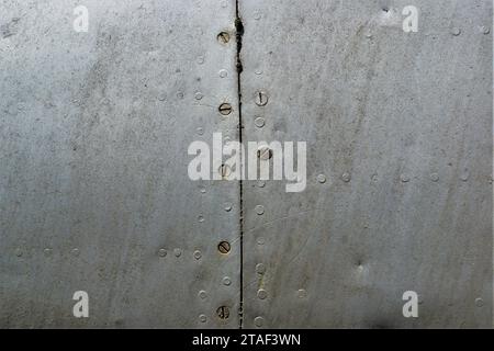 Ein Fragment eines sehr alten Flugzeugrumpfes. Vintage-Metallic-Hintergrund. Stockfoto