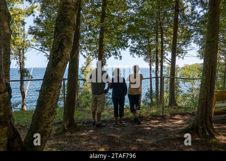 DOOR CO, WI - 15. August 2023: Drei Senioren sehen eine Seeszene in einem bewaldeten Gebiet eines Wisconsin State Park. Stockfoto
