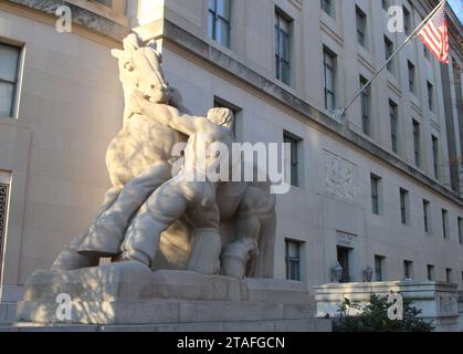 Washington, DC, USA. November 2023. Außenansicht des Hauptquartiers der Federal Trade Commission in 600 Pennsylvania Avenue NW in Washington, DC, USA, am 28. November 2023. An den Seiten der Pennsylvania Avenue und der Constitution Avenue befinden sich Reiterstatuen mit dem Namen man Controlling Trade, die von Michael Lantz geschaffen wurden. Die Arbeiten wurden 1942 geweiht. Die FTC setzt nationale Wettbewerbs- und Verbraucherschutzgesetze durch, die wettbewerbswidrige, irreführende und unlautere Geschäftspraktiken verhindern. (Foto: Carlos Kosienski/SIPA USA) Credit: SIPA USA/Alamy Live News Stockfoto