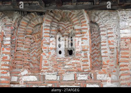 085 Rundbogen, Pfostenfenster aus rotem Ziegelwerk, das in die südwestliche Wand der Kirche St. Maria Vllaherna geschnitten wurde. Berat-Albanien. Stockfoto