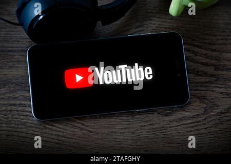 YouTube-App auf dem Smartphone auf einem Tisch zu Hause. Video-Streaming-Anwendung auf dem Bildschirm des Mobiltelefons. Stockfoto