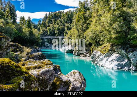 Türkisfarbenes Wasser fließt durch die Hokitika Gorge inmitten üppiger Vegetation und Felsformationen. Stockfoto