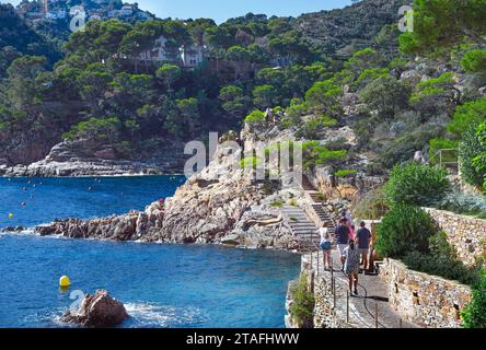 Urlauber wandern entlang des Camino de Ronda, einem Küstenwanderweg durch eine wunderbare Landschaft zum berühmten Sandstrand von Aiguablava. Costa Brava, Spanien Stockfoto