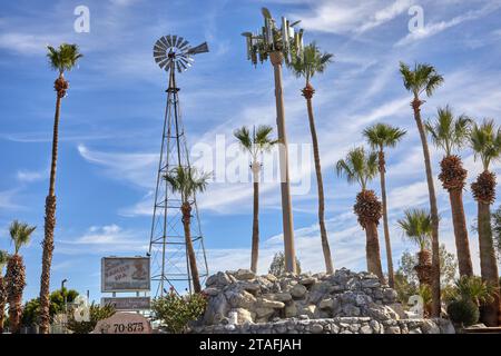 Desert Hot Springs, Kalifornien, USA. November 2023. Das Vintage-Schild für Sam's Family Spa & Hot Water Resort. Umgeben von Palmen, einer alten Windmühle mit Wetterfahne und einem Mobilfunkturm. (Kreditbild: © Ian L. Sitren/ZUMA Press Wire) NUR REDAKTIONELLE VERWENDUNG! Nicht für kommerzielle ZWECKE! Stockfoto