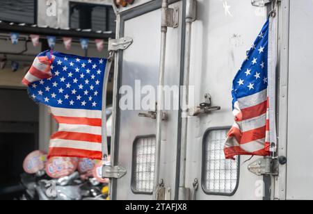 Zerrissene US-Flaggen fliegen auf einem fahrenden Truck Stockfoto