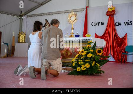 Ein Paar mittleren Alters, das in Anbetung des Allerheiligsten Sakraments kniet. Ein Zelt im Heiligtum Christi des Königs in Lissabon, Portugal während des WJD 2023. Stockfoto