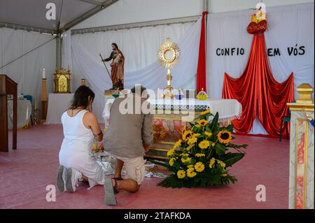 Ein Paar mittleren Alters, das in Anbetung des Allerheiligsten Sakraments kniet. Ein Zelt im Heiligtum Christi des Königs in Lissabon, Portugal während des WJD 2023. Stockfoto