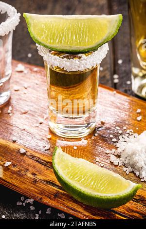 Gläser goldener Tequila, serviert mit Salz und Zitrone, auf einer alten Karte von mexiko Stockfoto