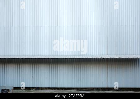 Texturierte Wellblechverkleidung an der Fassade von Industriebauten auf der temporären Baustelle. Stockfoto