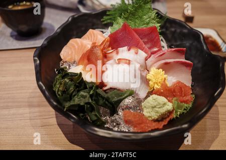 Blick von oben auf Sashimi mit verschiedenen rohen frischen Scheiben Fisch, Tintenfisch und Tintenfisch, auf der Holztheke. Stockfoto