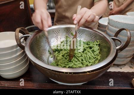 Nahaufnahme und Blick von oben auf Lod Chong oder Cendol, süßes Eis-Dessert, berühmt in Südostasien, im Aluminiumsieb bereit zum Servieren. Stockfoto