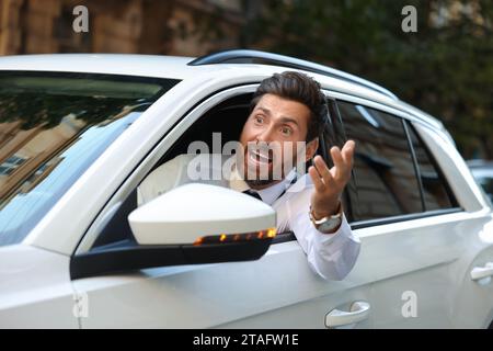 Wütender Fahrer, der jemanden aus dem Auto im Stau anschrie Stockfoto