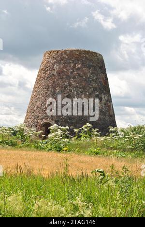 Ruinen einer alten Windmühle in der Nähe von Sabile, Lettland auf einer Wiese Stockfoto