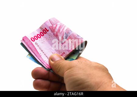 Die indonesische Rupiah ist die offizielle Währung Indonesiens. Die Hand des asiatischen Mannes hält etwas Geld, um zu bezahlen. Wirtschaftskonzept Investitionsgeschäft Stockfoto