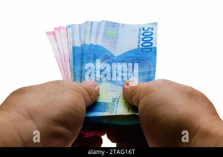 Die indonesische Rupiah ist die offizielle Währung Indonesiens. Die Hand des asiatischen Mannes hält etwas Geld, um zu bezahlen. Wirtschaftskonzept Investitionsgeschäft Stockfoto