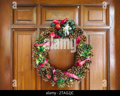 An der Holztür hängt der Weihnachtskranz Stockfoto