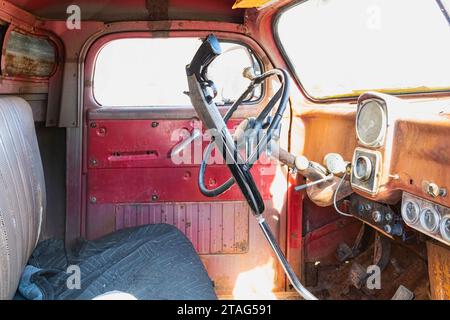 Vintage-Vibes und Geschichten über die offene Straße – ein alter rostiger Pickup-Truck mit Schrotflintenschaltung erzählt von rauen Abenteuern und zeitlosen Erinnerungen. Stockfoto
