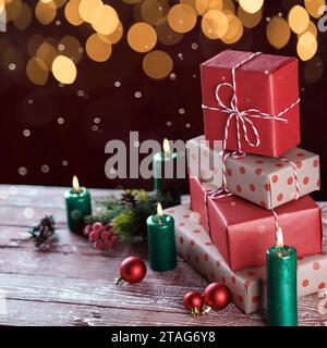 Weihnachtsgeschenkboxen mit Kerzen auf hölzernem Hintergrund. Hochwertige Fotos Stockfoto