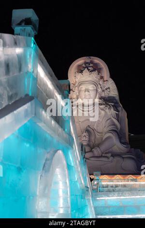 HARBIN, CHINA - 1. Januar 2022: Vertikale Abbildung der spektakulären beleuchteten weißen Eisskulpturen beim Harbin Ice and Snow Festival in Harbin, Hei Stockfoto