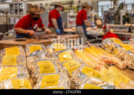 Im großen Reisezentrum Buc-ees an der I-95 in Daytona Beach, Florida, warten fertige Grillgerichte auf Sie, während die Mitarbeiter Brisket hacken und Sandwiches zubereiten. Stockfoto