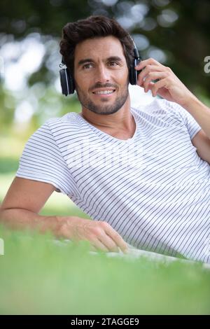 Ein Mann ruht sich im Park aus und hört Musik Stockfoto