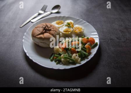 Gesundes Frühstück Brot, Eier und gekochtes Gemüse auf einem Teller. Stockfoto