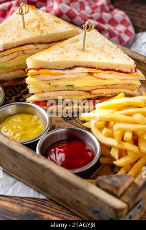 Chicken Club Sandwich mit Pommes, Ketchup, Senf und Mayonnaise Stockfoto