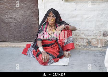 Alte indianerin sitzt auf dem Boden im Dorf Bishnoi in Jodhpur, Rajasthan - Indien Stockfoto