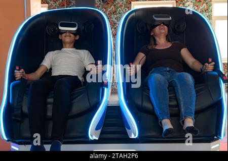 Virtual-Reality-Attraktion: Sohn und Mutter erleben Adrenalin aus Virtual-Reality-5D-Sensation. Stockfoto