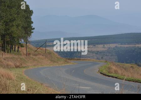 Straße über Bauernhöfe in Südafrika in Richtung ferne Berge Straße über Bauernhöfe in Südafrika in Richtung ferne Berge Stockfoto