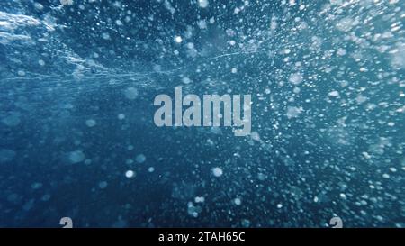 Luftblasen steigen vom Meeresboden zur Wasseroberfläche auf, verstärkt durch das Ausatmen eines Tauchers. Eine ideale Wahl für eine abstrakte und ruhige Atmosphäre Stockfoto