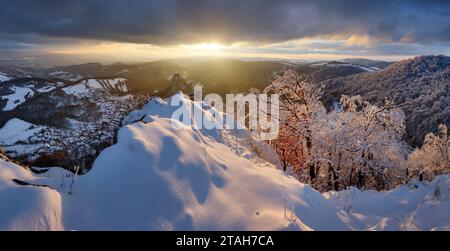 Wunderschöne Landschaft des Tales in der Slowakei Berge im Winter, kleine Häuser im Dorf, ländliche Szene, majestätische malerische Aussicht bei Sonnenuntergang Panorama Stockfoto
