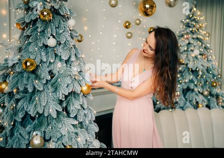 Young woman decorates the christmas tree, New Year atmosphere Stockfoto