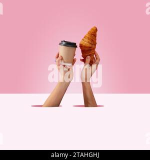 Die Hände der Frauen halten eine Tasse Kaffee und ein Croissant Stockfoto