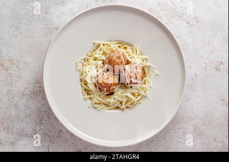 Pasta in Sahnesauce mit Fleischbällchen und geriebenem Parmesan Stockfoto