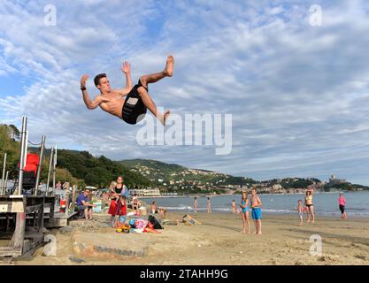 LERICI, ITALIEN - 15. JUNI 2016: Guy springt am Strand in Lerici, Italien. Stockfoto