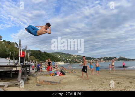 LERICI, ITALIEN - 15. JUNI 2016: Guy springt am Strand in Lerici, Italien. Stockfoto