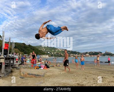 LERICI, ITALIEN - 15. JUNI 2016: Guy springt am Strand in Lerici, Italien. Stockfoto