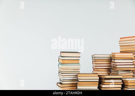 Viele Stapel von Lehrbüchern auf weißem Schulbibliothekenhintergrund Stockfoto