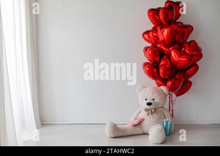 Rote Ballons in Herzform mit Weihnachtsgeschenken Stockfoto