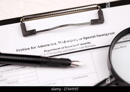 I-360 Petition für Amerasian-, Witwer- oder spezielle Einwanderungsleerform auf A4-Tablette liegt auf dem Bürotisch mit Stift und Lupe in Nahaufnahme Stockfoto