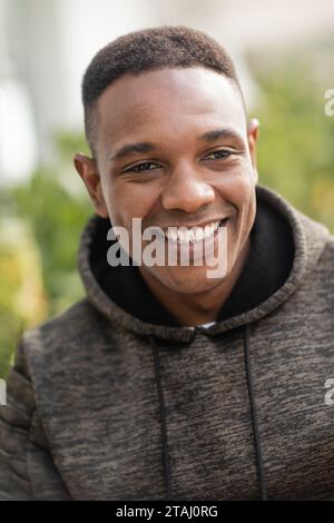 Porträt eines positiven afroamerikanischen Mannes im Hoodie, der draußen lächelt Stockfoto