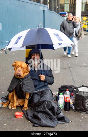 London, Großbritannien. November 2023. Ein Obdachloser sitzt vor der Waterloo Station mit seinem freundlichen Bullen Mastiff Hund. Crisis at Christmas führt ihre jährliche Weihnachtskampagne durch, in der die Menschen aufgefordert werden, Geld zu spenden, um Obdachlosen zu helfen, am Weihnachtstag eine warme Mahlzeit zu essen Stockfoto