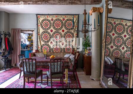 Suzani Wandbehang mit Teppich, der als Tischdecke im Essbereich des georgianischen Scheunenbaus in Tetbury, Gloucestershire, Großbritannien, verwendet wurde. Stockfoto