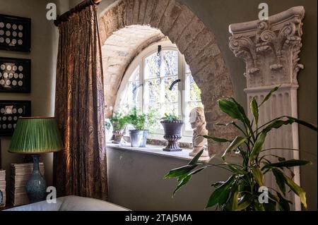 Intaglios römischer Kaiser mit Sari-Stoff-Lampenschirm am ursprünglichen Cotswold-Steinfenster in georgianischer Scheune, Tetbury, Gloucestershire, Großbritannien. Stockfoto