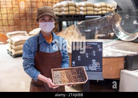 (231201) -- PEKING, 1. Dezember 2023 (Xinhua) -- Ein Mitarbeiter zeigt Proben roher und gerösteter Kaffeebohnen im Starbucks Reserve Roastery im ostchinesischen Shanghai, 24. November 2023. Auf der laufenden China International Supply Chain Expo (CISCE) hat der US-amerikanische Kaffeeriese Starbucks durch seine Kaffeekette und seine Produkte große Aufmerksamkeit auf sich gezogen. Starbucks kam 1999 auf das chinesische Festland und betreibt heute mehr als 6.800 Geschäfte in über 250 chinesischen Städten. 2012 wurde in Pu'er in der Provinz Yunnan ein Starbucks Farmer Support Center gegründet, das erste seiner Art in Asien, um bo weiter zu fördern Stockfoto